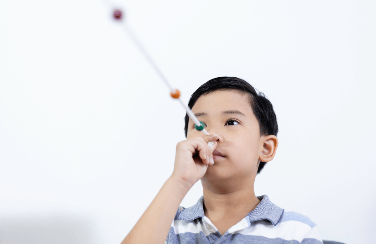 a young boy using a brock string for vision therapy